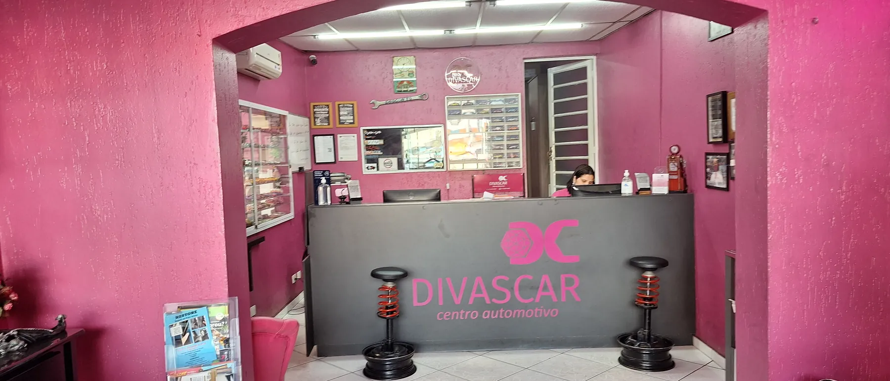Recepção da Divas Car, com o balcão cinza e o logo rosa